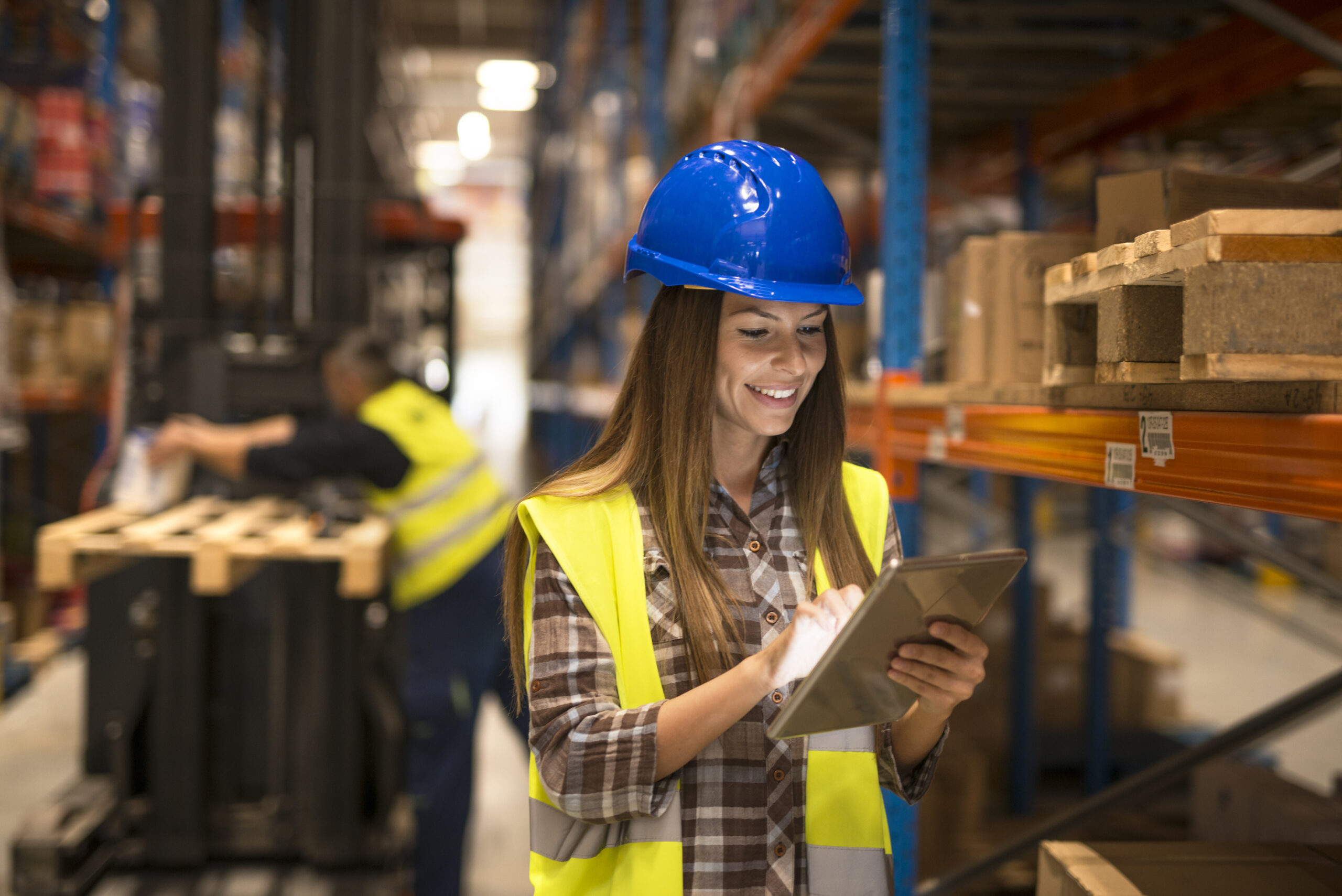 Female warehouse worker holding tablet checking inventory in distribution warehouse | FreightbyTruck